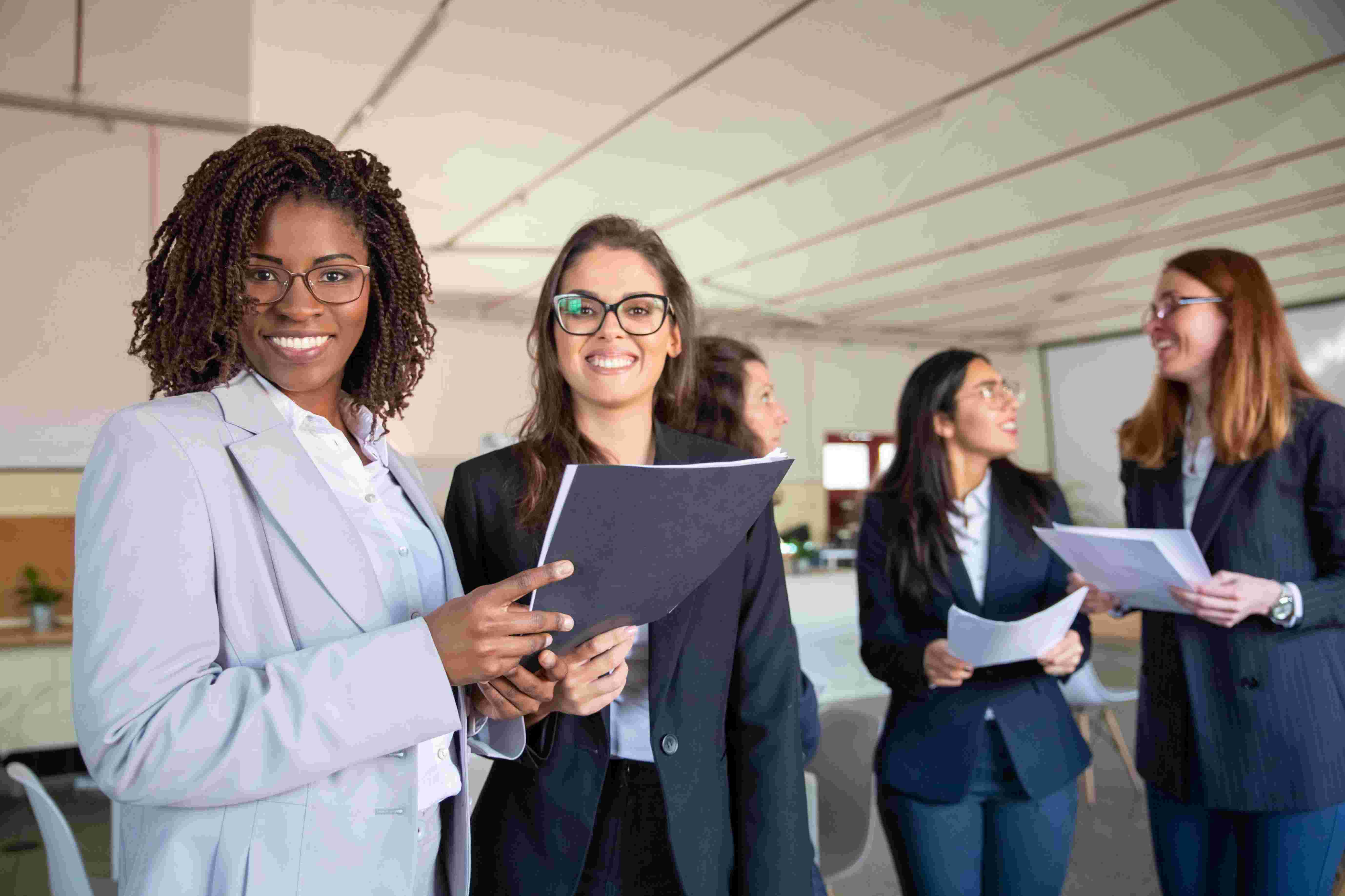  group-smiling-women-holding-paper-documents